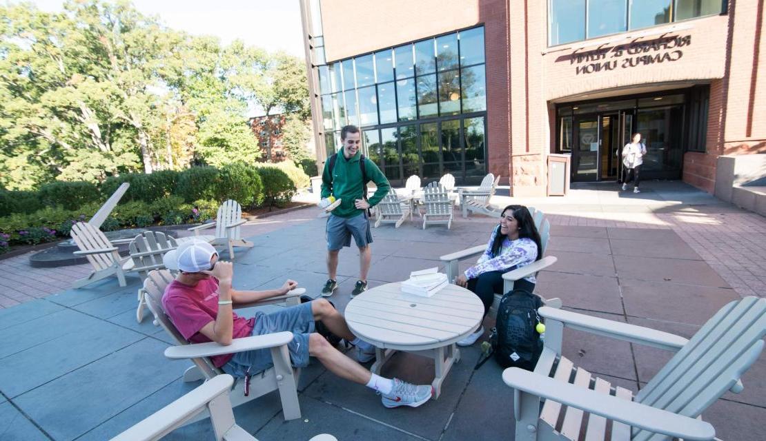 Students sit outside on a sunny day on campus.